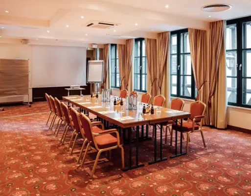 Tagungsraum im Gothischen Haus Ein Zimmer mit einem Tisch und Stühlen.