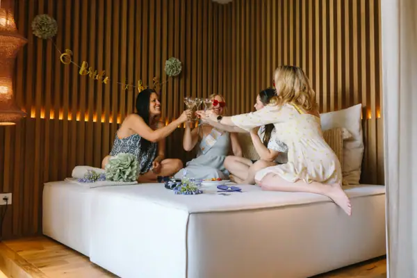 Feier in der SPA-Suite Gruppe von Freundinnen stößt in einer stilvollen SPA-Suite mit Getränken an.