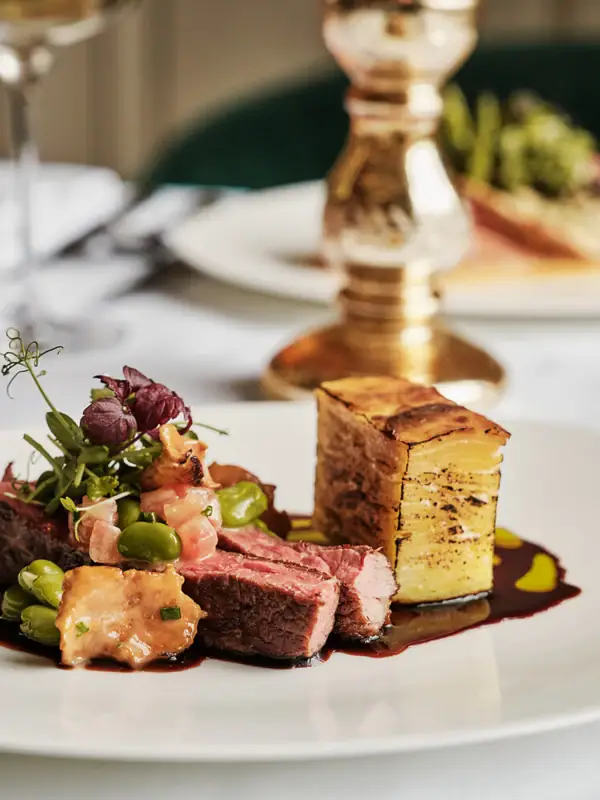 A-ROSA Gericht Ein Teller mit kunstvoll angerichteter Speise auf einem Tisch.