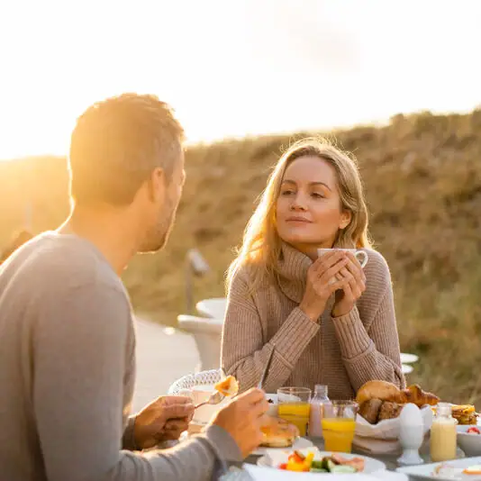 Ein Mann und eine Frau sitzen an einem Tisch mit Essen.