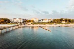 A-ROSA Ostseehotel Kühlungsborn Ein Gewässer mit einem Steg und Gebäuden im Hintergrund.