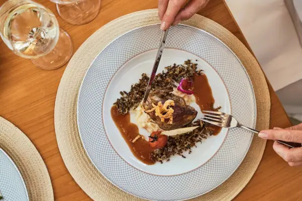 Ein Teller mit Essen und Weingläsern auf einem Tisch.