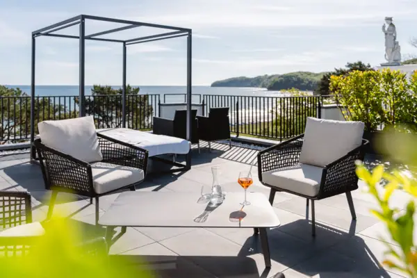 A-ROSA Ceres am Meer Terrasse Eine Terrasse mit Stühlen und einem Tisch auf einem Deck mit Blick auf das Meer.