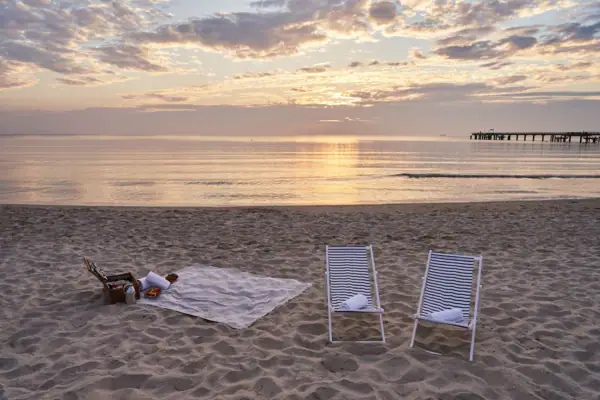 Strand Ein Strand mit Stühlen und einer Decke.