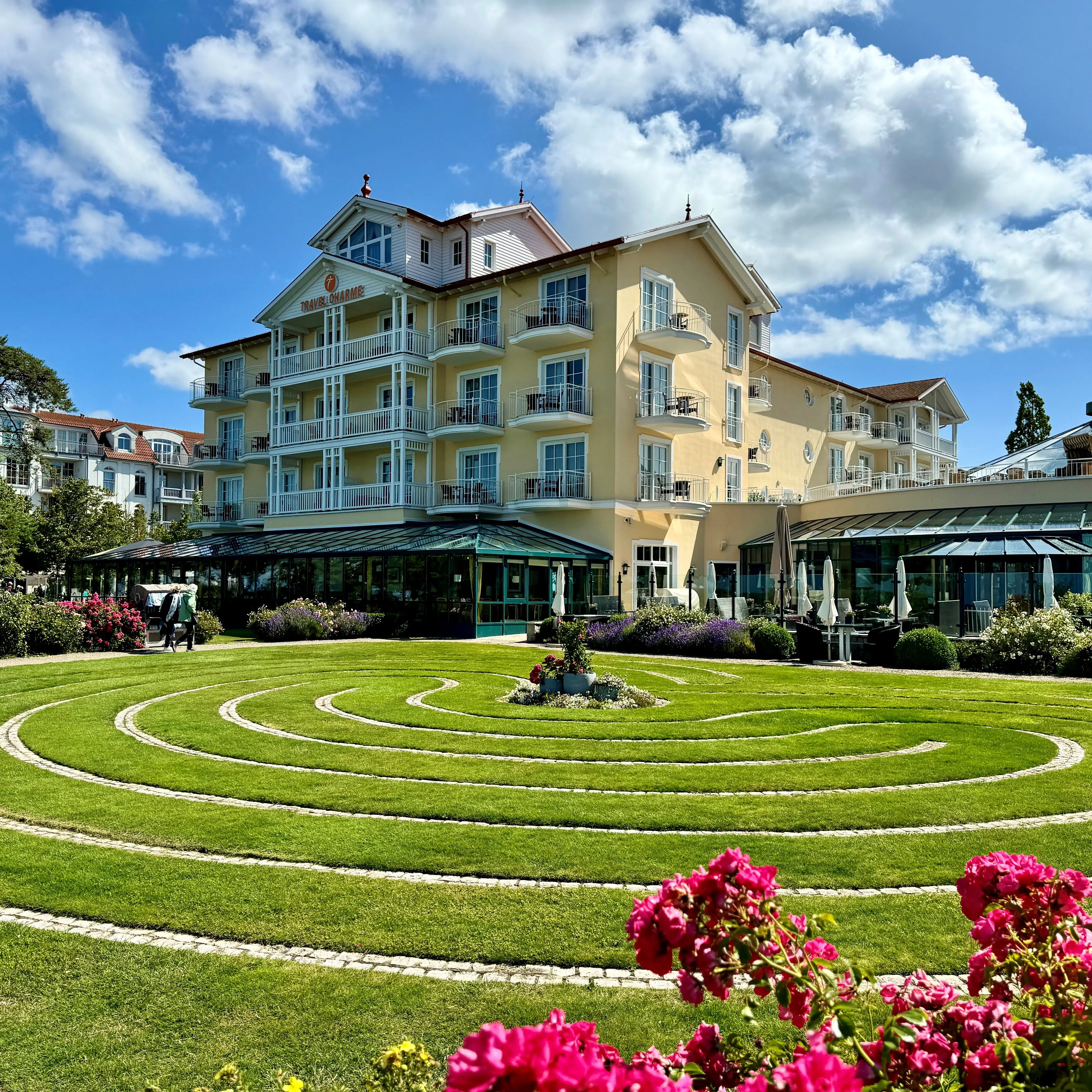 Ostseehotel Kühlungsborn Runder Rasen mit Blumen vor einem Gebäude.