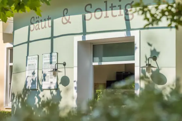 Bistro „Säut & Soltig“ im A-ROSA Ostseehotel Kühlungsborn Außenansicht des Bistros „Säut & Soltig“ mit Sonnenschein und grünen Blättern