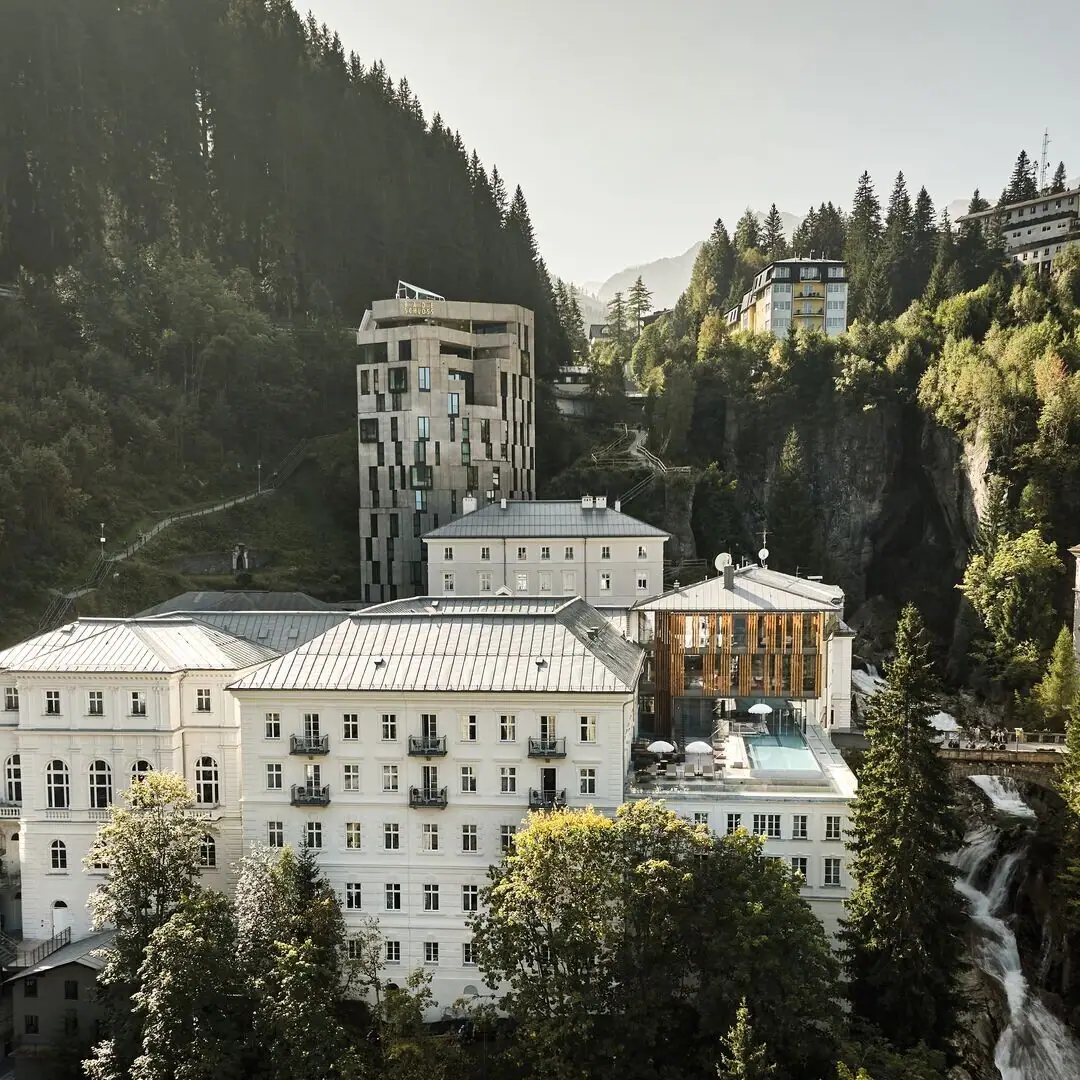 Straubinger Grand Hotel Eine Gruppe von Gebäuden mit Bäumen und Bergen im Hintergrund.