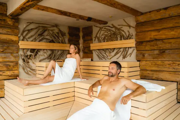 Treibholzsauna Ein Mann und eine Frau in einer Sauna.