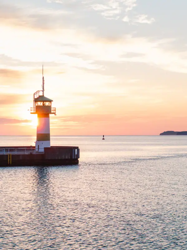Leuchtturm auf einem Steg inmitten des Ozeans.