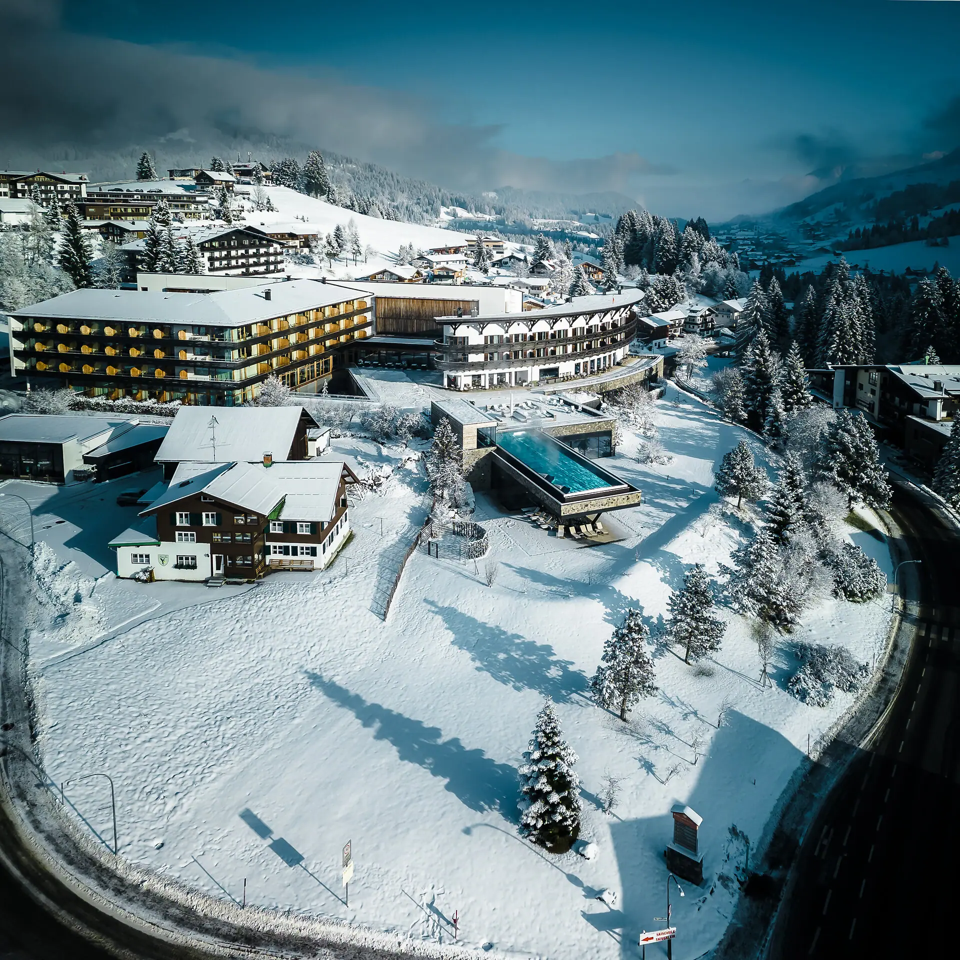 A-ROSA Ifen Hotel Kleinwalsertal Verschneite Landschaft mit Häusern und Bäumen.