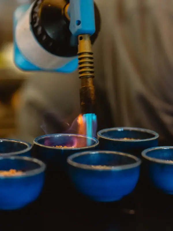 Tellerwerk Travemünde Eine Person hält einen Gasbrenner über eine blaue Schüssel.