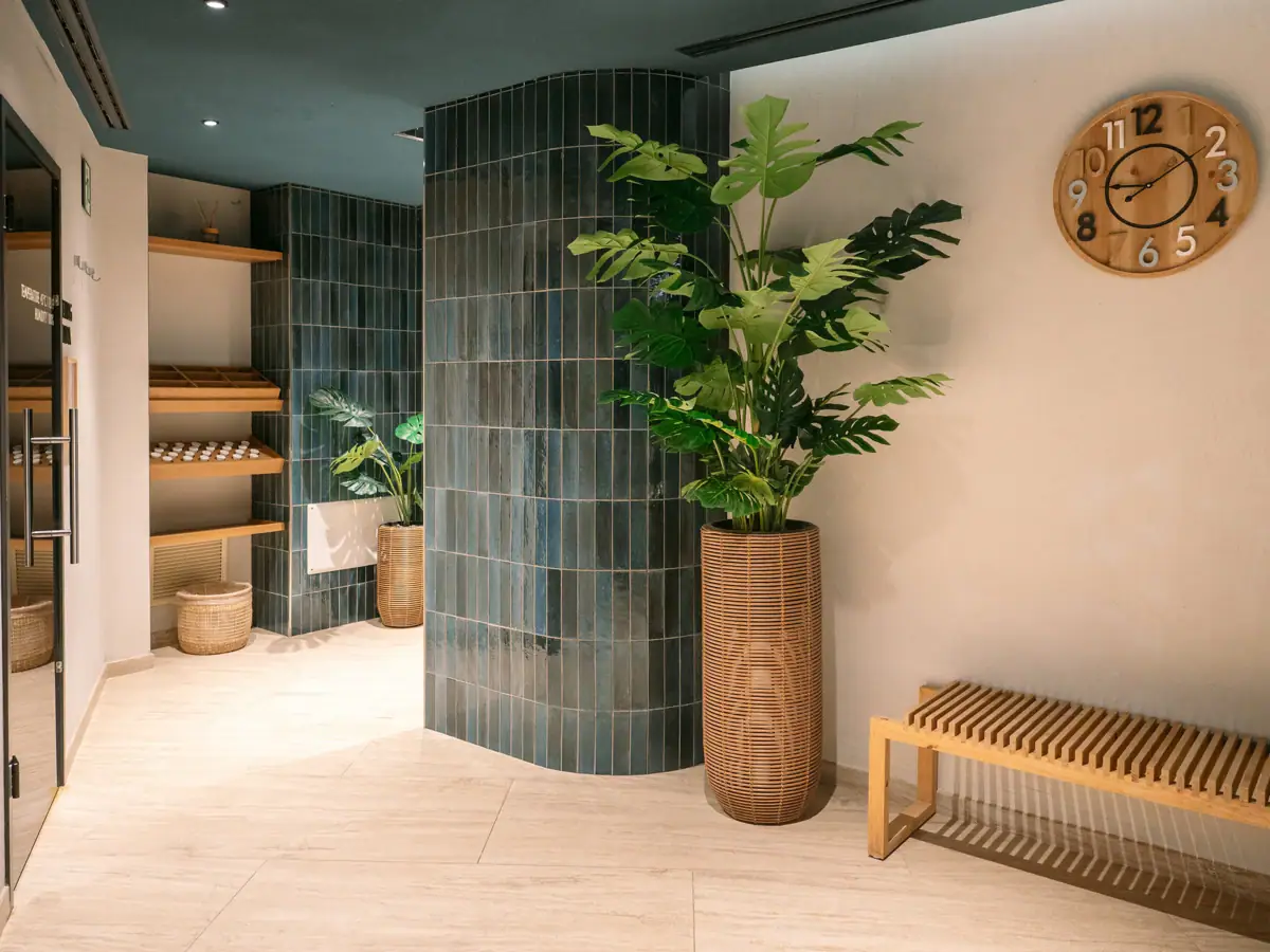 Moderner Saunabereich im A-ROSA Gardasee Stilvoll gestalteter Eingangsbereich des Saunabereichs im A-ROSA Gardasee mit Pflanzen, Holzbank und modernen Details.