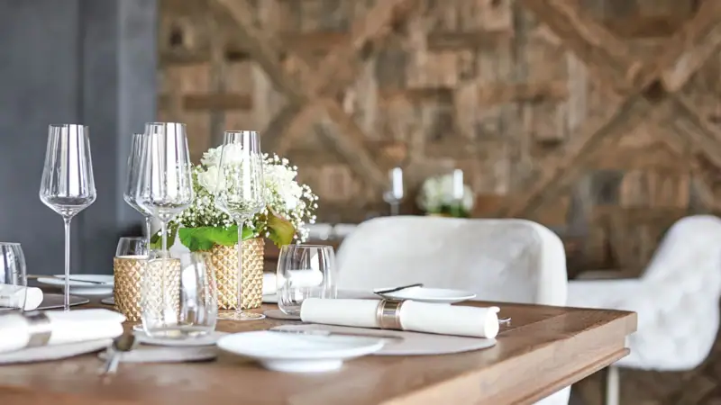 Ein Tisch gedeckt mit Weingläsern und Blumen.