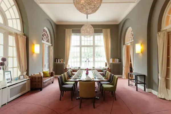 Restaurant Travemünde Ein Raum mit einem langen, eingedeckten Tisch und Stühlen.