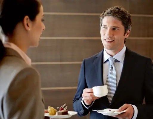 Ein Mann und eine Frau im Gespräch, beide in formeller Kleidung.