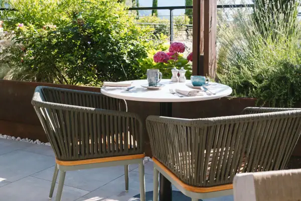 Ein Tisch und Stühle auf einer Terrasse.