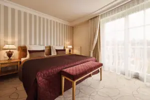 Zimmer Ein Bett mit einer Bank in einem Zimmer mit gestreiften Wänden.