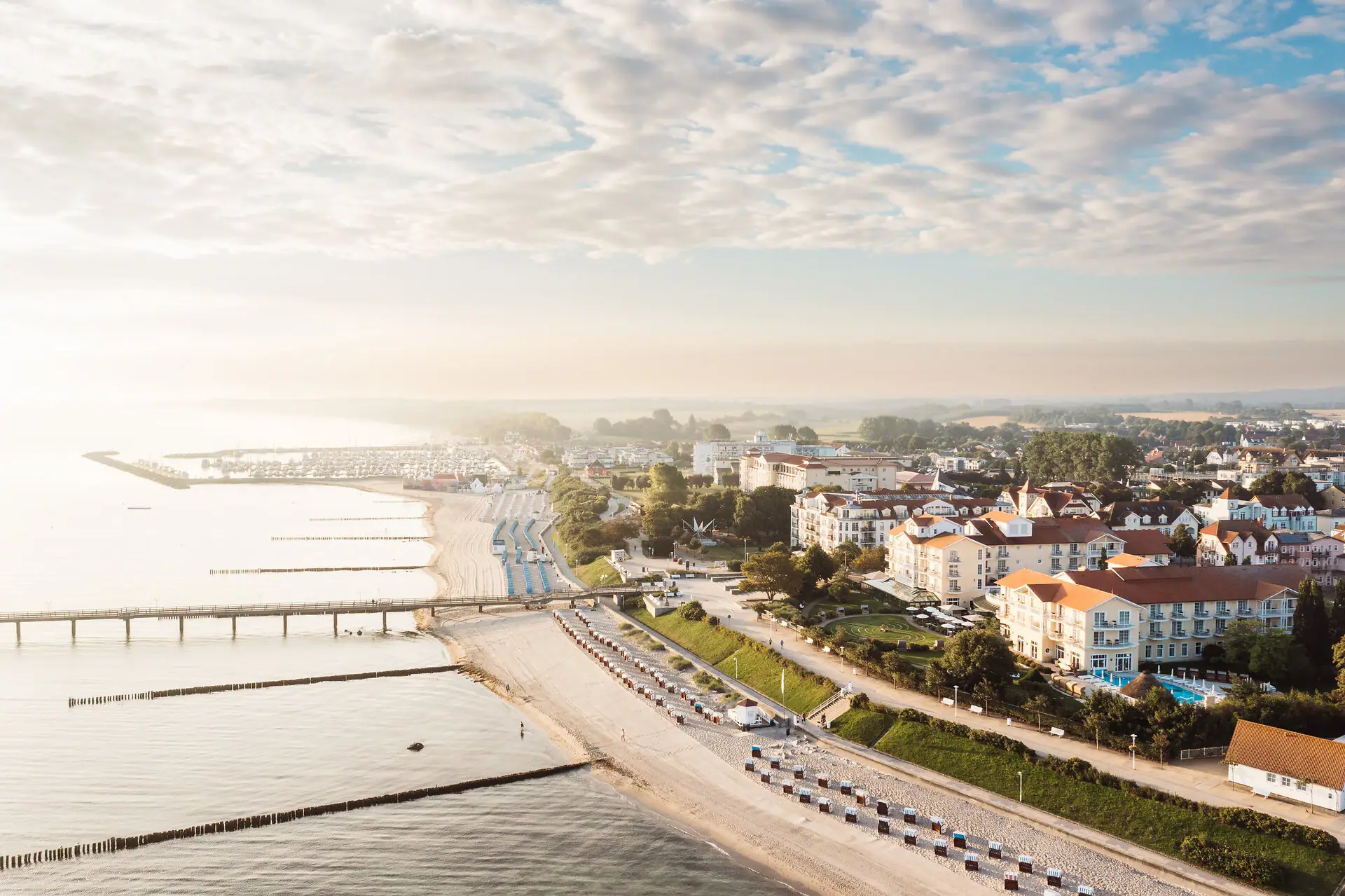 Kühlungsborn Strand mit Gebäuden und einer Brücke im Hintergrund.