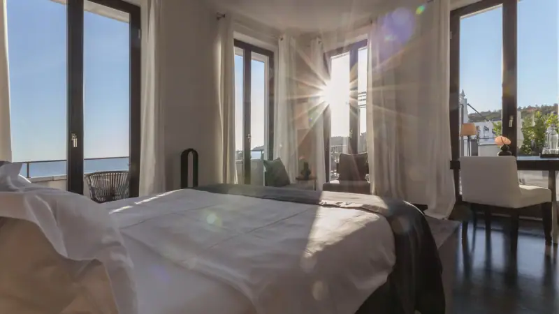 Zimmer & Suiten Ein Zimmer mit einem Bett und Fenstern.