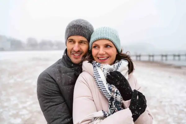 Travemünde im Winter Ein Mann und eine Frau in Winterkleidung lächeln im Freien.