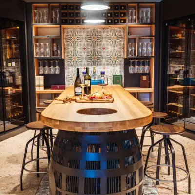 Enoteca im A-ROSA Gardasee Ein Tisch mit Weinflaschen darauf.