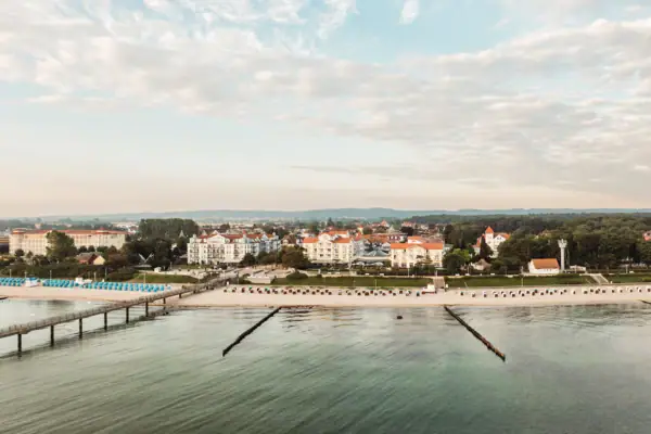 A-ROSA Ostseehotel Kühlungsborn Ein Gewässer mit Gebäuden und Bäumen im Hintergrund.