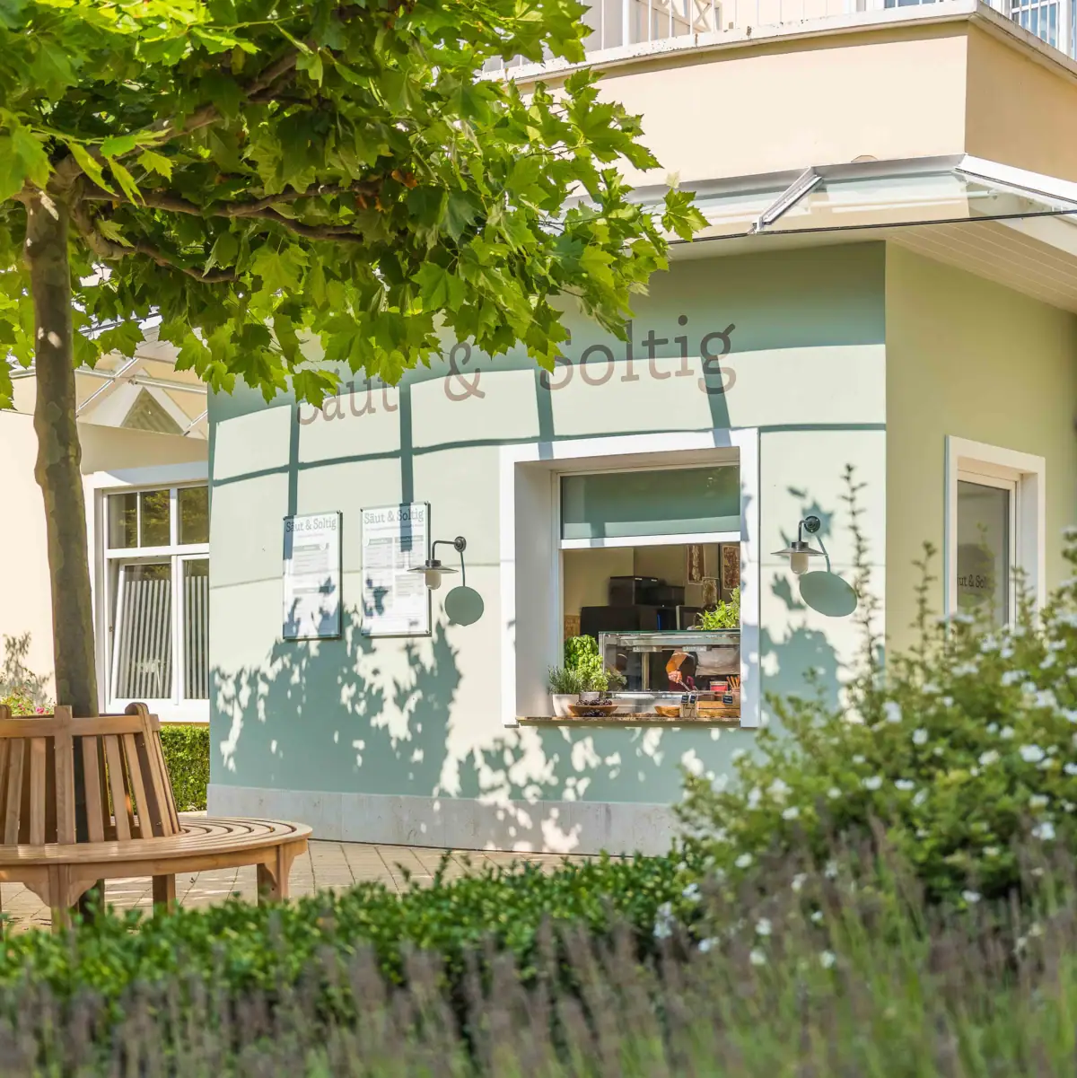 Ein Gebäude mit einer Bank und einem Baum davor.