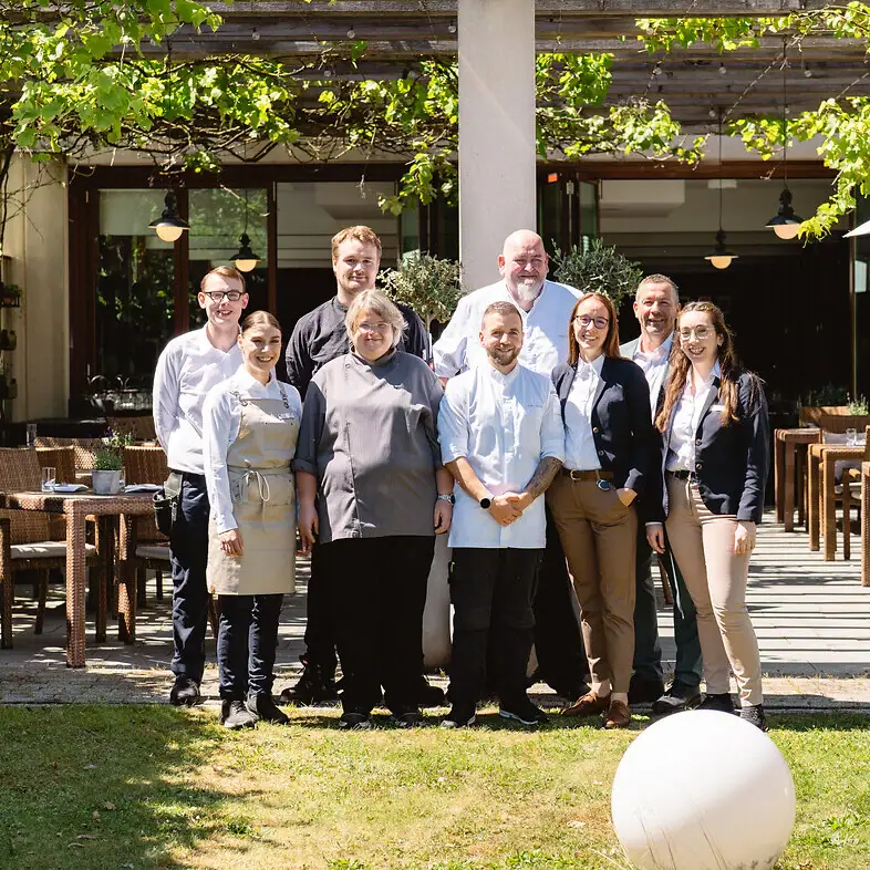 Eine Gruppe von Menschen steht vor einem Gebäude.