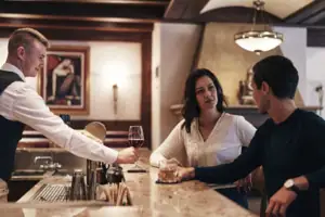 Tresen Ein Mann bedient eine Frau an einer Bar.