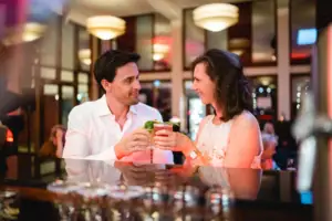 Marktplatzbar Ein Mann und eine Frau halten Getränke in einem Restaurant.