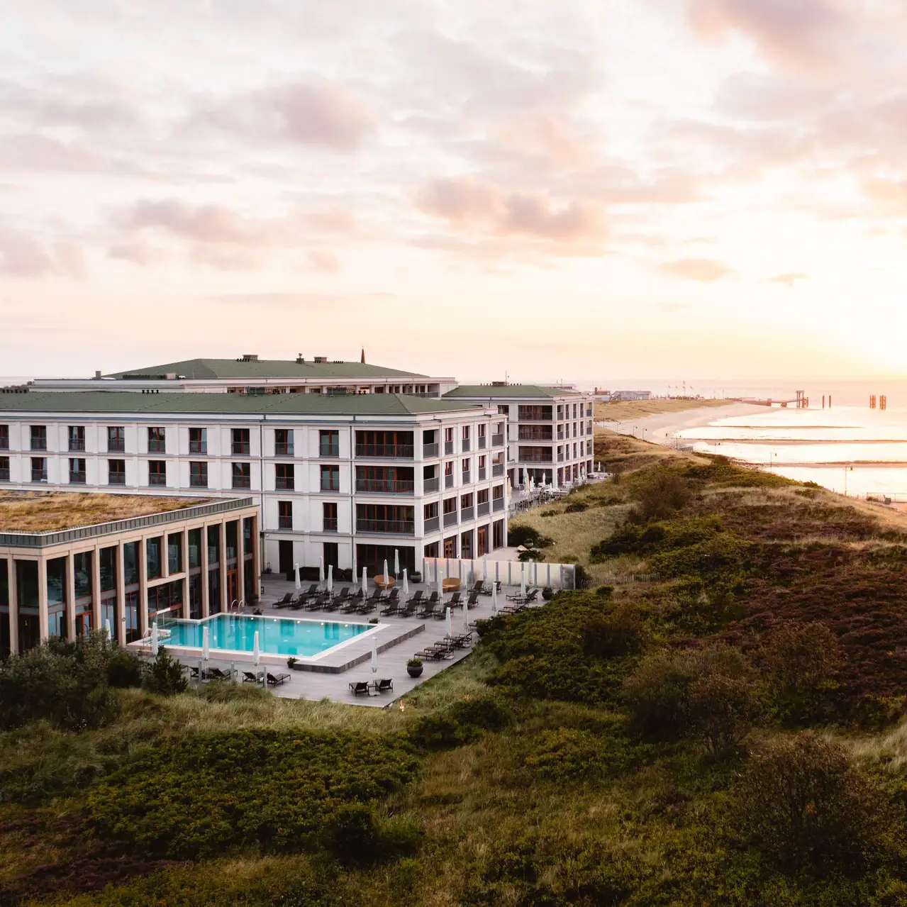 Ein Gebäude mit einem Pool am Wasser unter freiem Himmel.