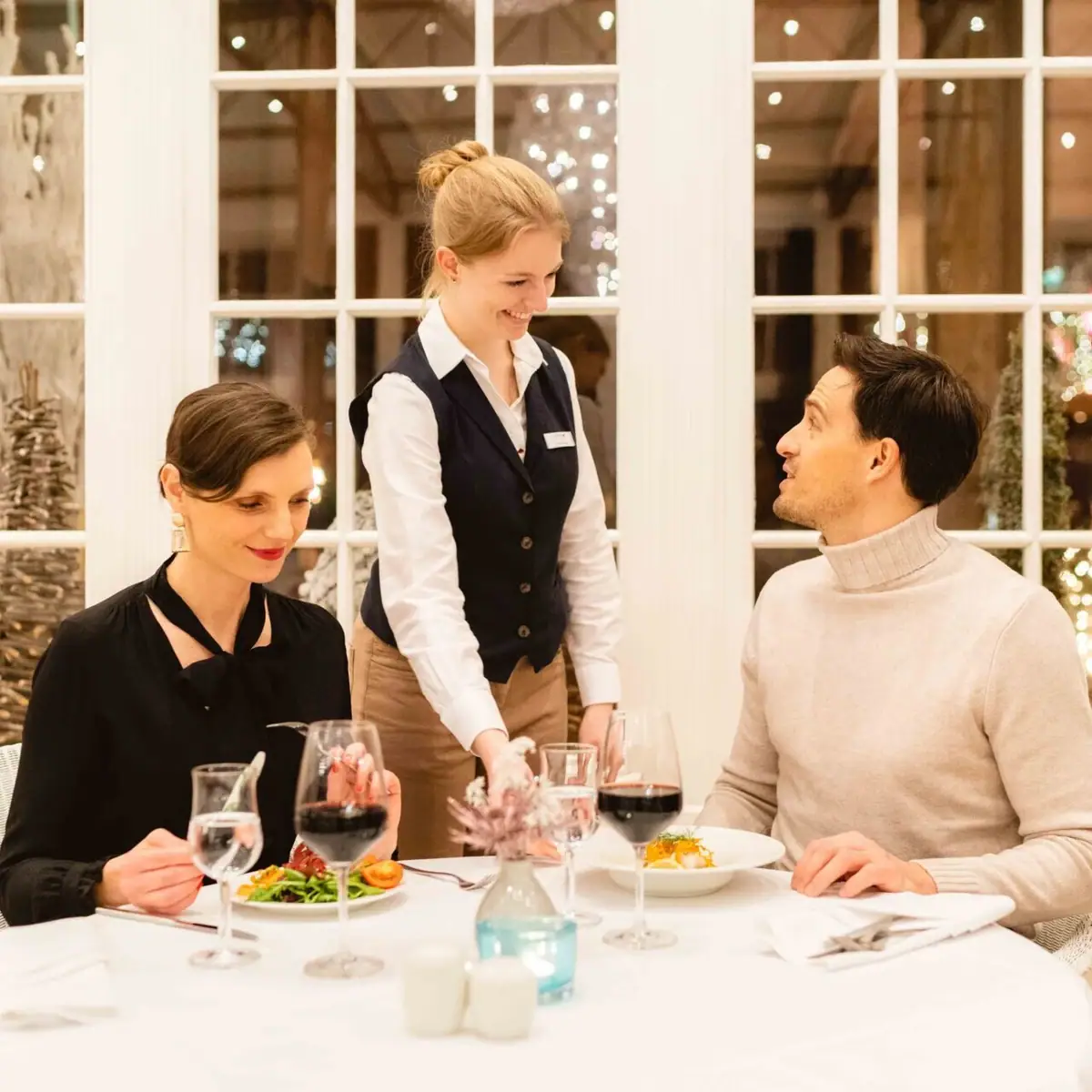 Festtage bei A-ROSA Eine Gruppe von Menschen an einem Tisch mit Weingläsern und Tischgeschirr.